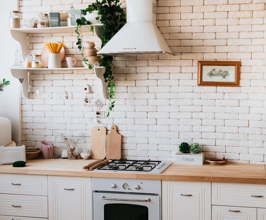 Stylish kitchen interior with modern appliances, wooden counters, and greenery accents.