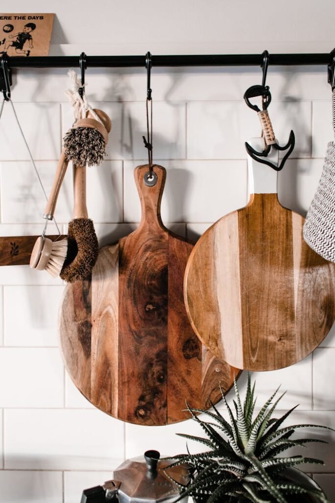 Stylish kitchen interior with wooden cutting boards and hanging utensils.