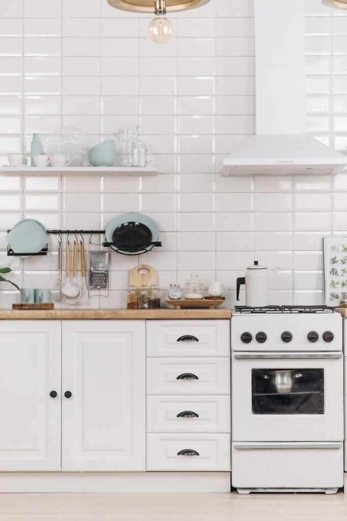 Modern kitchen interior with white cabinets and stove, minimalist design.